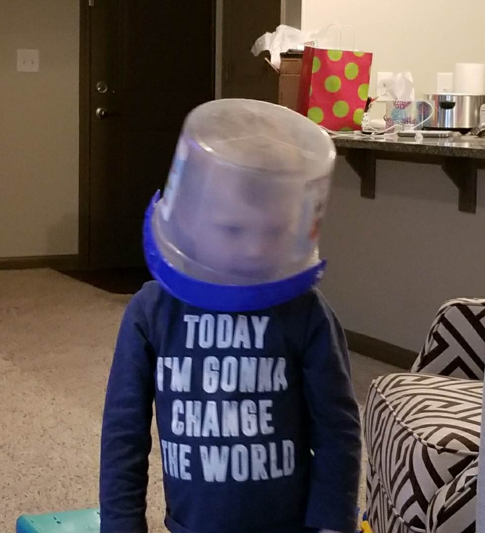 Picture of Sean's nephew, Roman, with a bucket on his head wearing a shirt that says 'today I'm gonna change the world'